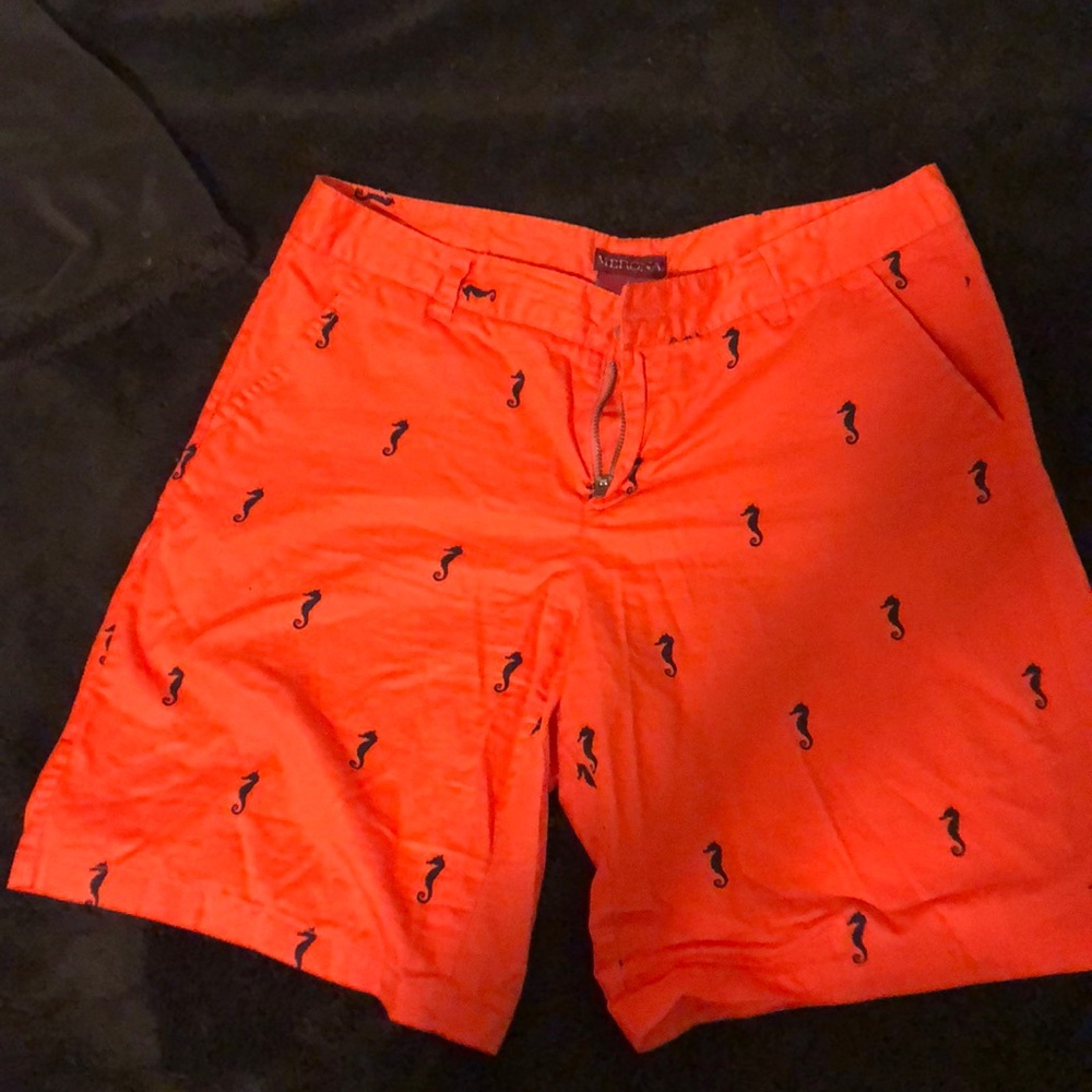 Bright orange shorts with dark blue sea horses.